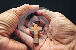 The crucifix is in the hands of a man who is praying for the blessing of his god with faith