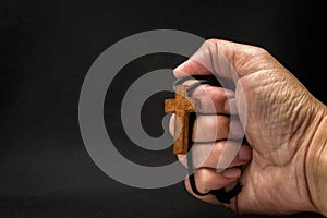 The crucifix is in the hands of a man who is praying for the blessing of his god with faith