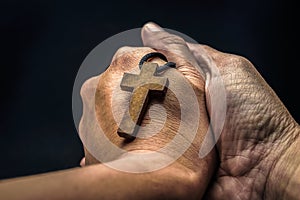 The crucifix is in the hands of a man who is praying for the blessing of his god with faith