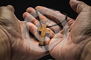 The crucifix is in the hands of a man who is praying for the blessing of his god with faith