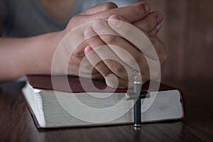 The crucifix in human hands rests on the Bible. Concepts for the study of Christians, Christianity, Catholicism, God, Heaven,