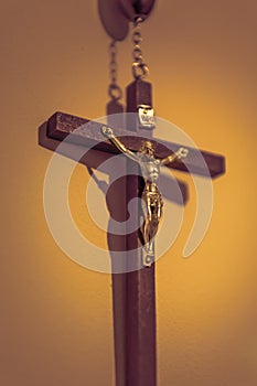 Crucifix with part of rosary on the yellowish background