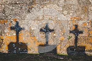 crucifix shadow on stone wall