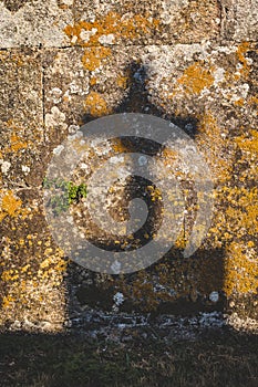 crucifix shadow on stone wall