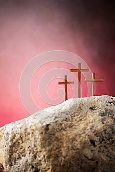 Crucifixion, resurrection of Jesus Christ. Three crosses against red sky on Calvary hill background. Christian Easter