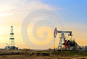 Crude oil pump jack at oilfield on atmospheric sunset backround. Fossil crude output and fuels oil production. Oil drill rig and