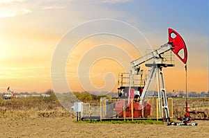 Crude oil pump jack at oilfield on atmospheric sunset backround. Fossil crude output and fuels oil production. Oil drill rig and