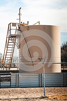 A crude oil storage tank to collect oil as it is pumped.