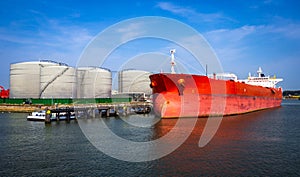 Crude oil tanker docked at a oil storage silo terminal in the port