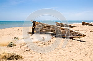 Crude wooden fishing boats lying on yellow beach near Lobito, Angola photo