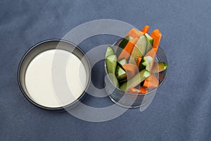 Crudites is a set of fresh raw vegetables cut into thin strips with homemade cheese sauce. Top view, selective focus