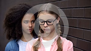 Cruel black student bullying caucasian schoolgirl eyeglasses, emotional pressure