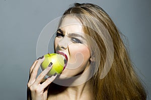 Cruel blonde girl with apple