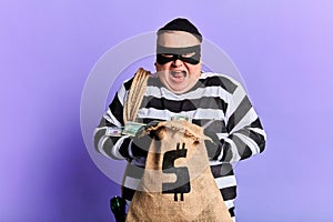 Cruel guilty thief holding a sack and loking at the camera
