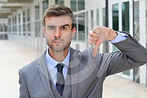 Cruel man giving a solid thumbs down photo