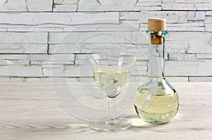 Cruet of White Wine and Glass on a Wooden Table