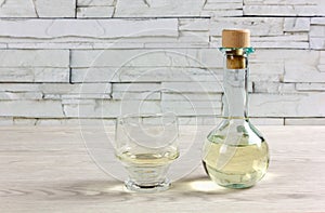 Cruet of White Wine and Glass on a Wooden Table