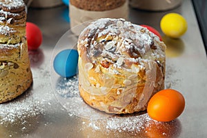 Cruffin as Easter cake decorated with raisins, dried apricots and sugar powder on kitchen table among easter eggs