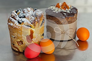 Cruffin and brown Easter cake decorated with chocolate, almond flakes and dried apricots on kitchen table among easter eggs