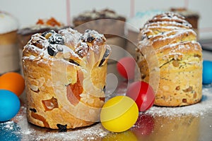 Cruffins as Easter cakes decorated with raisins, dried apricots and sugar powder on kitchen table among easter eggs