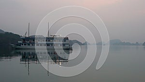 Cruise Boat floating in Ha Long Bay at dusk, North East Vietnam