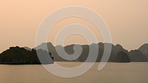 Cruise Boat in Ha Long Bay at Sunset in the limestone islands of Cat Ba National Park, North East Vietnam