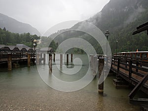 Cruise boat landing on Konigssee lake on a cold, rainy, foggy day