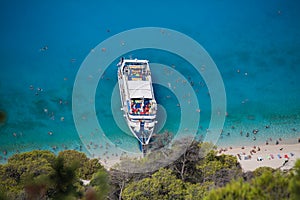 Cruise boat seen from above on clear blue water