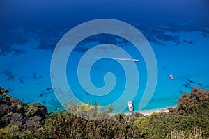 Cruise boat seen from above on clear blue water