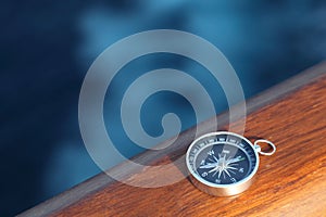 Cruise compass on wooden rail sea