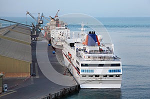 Cruise liner, cargo ships and crane at port photo