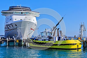 Cruise liner `Carnival Spirit` and tugboat in port