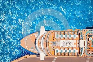 Cruise liner luxury ship in port, blue sea water. Top aerial view.