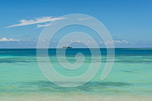 Cruise liner in light green and dark blue water of Pacific Ocean