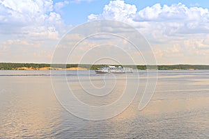 Cruise river ship sails along the Volga River on a sunny summer day