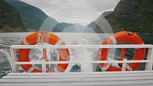 Cruise ship cruise with two lifebuoys. In the background, the picturesque Norwegian fjord