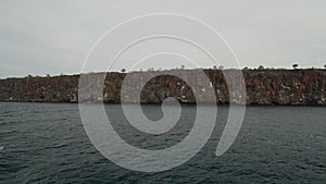 cruise ship cruising along the rugged coastline of Galapagos