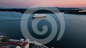 A cruise ship leaving the port of the picturesque town at sunrise