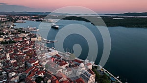 A cruise ship leaving the port of the picturesque town at sunrise