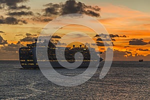 A cruise ship leaving port and sailing into the sunset