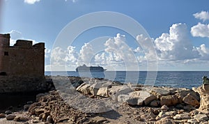 A cruise ship liner on a sunny day against the blue sky moves to the open sea, side view.