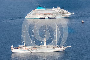 Cruise ship and luxury yacht aerial view, Santorini Greece. Calm blue sea and sea transportation vessels