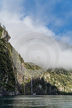 Cruise ship in Milford sound beneath waterfall