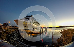 Cruise ship moored in port of a city at sunset