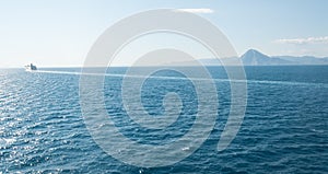 Cruise ship near the horizon with a mountain in the background