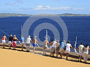 Cruise ship passengers on the deck arriving in Caribbean port