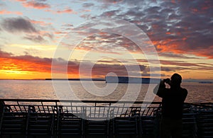 Cruise ship passengers taking pictures of sunset