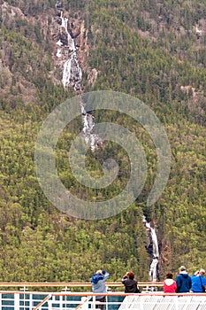 Cruise ship passengers viewing a waterfall in Alaska