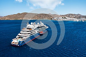Cruise ship in port. Aerial view of the ship from drone. Blue clear water in the Mediterranean Sea. Summer vacation and travel on