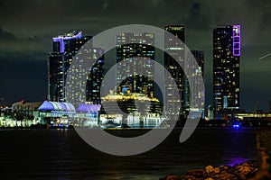 Cruise ship in the Port of Miami at sunset with multiple luxury yachts. Miami night downtown, city Florida. Night view